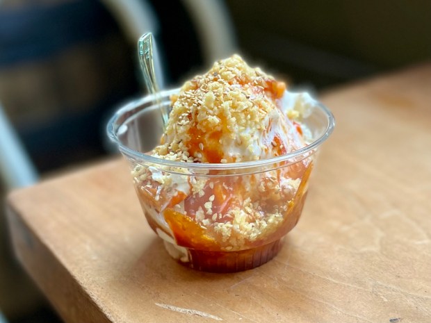 Sundae with gochujang caramel, rice vinegar macerated peaches, crushed Honey Butter Chips, sesame seeds and Maldon sea salt over vanilla ice cream by chef Won Kim of Kimski restaurant for Sundae Monday at Longman & Eagle in the Logan Square neighborhood of Chicago on July 14, 2025 (Louisa Kung Liu Chu/Chicago Tribune)