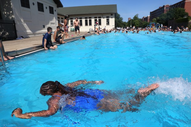 A young woman moves through the deep end while cooling...
