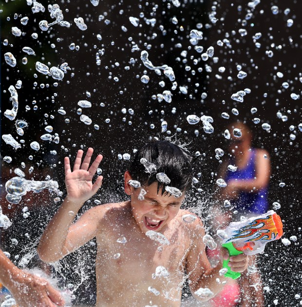 Joseph Perez reacts as water pours over the 6-year-old as...
