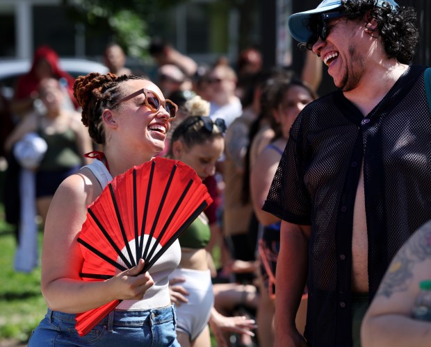 Jamitra Fulleord, left, fans herself to cool off while talking...