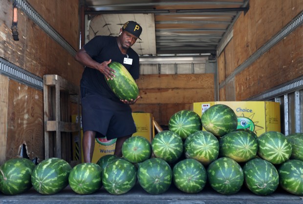 Vendor Lavar Jackson pulls a watermelon out of his truck...