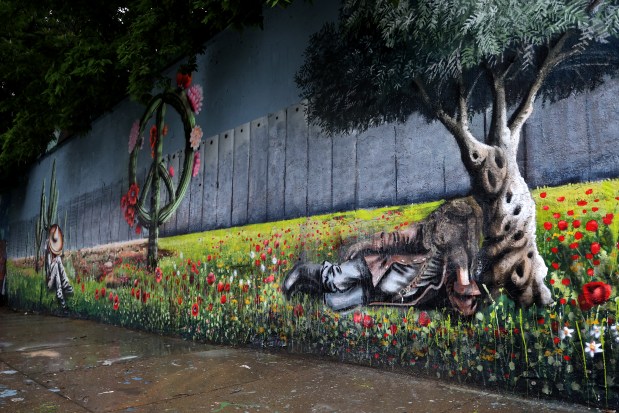 A vandalized mural with a burned face of a Palestinian man, along 16th Street near Ashland Avenue in Chicago's Pilsen neighborhood on June 18, 2025. (Antonio Perez/Chicago Tribune)