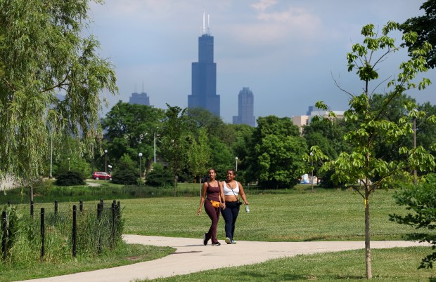 Willis Tower is in the distance as two women laugh...