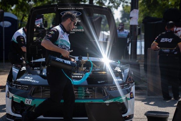 A crew works on Buildsubmarine.com's car during the NASCAR Xfinity...