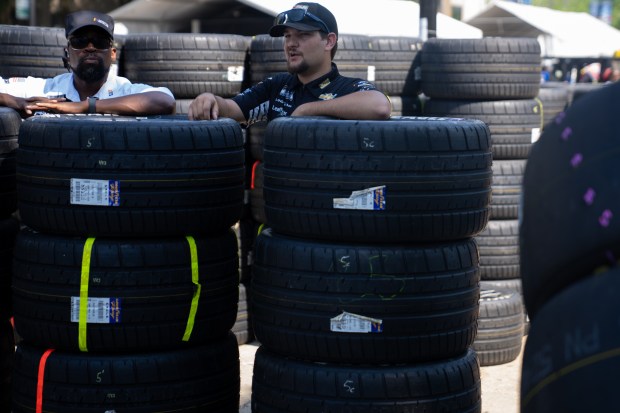 Workers rest on the Goodyear tires during the NASCAR Xfinity...
