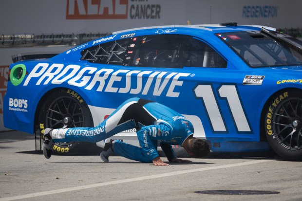 Josh Williams (11) leans under his car after a crash...