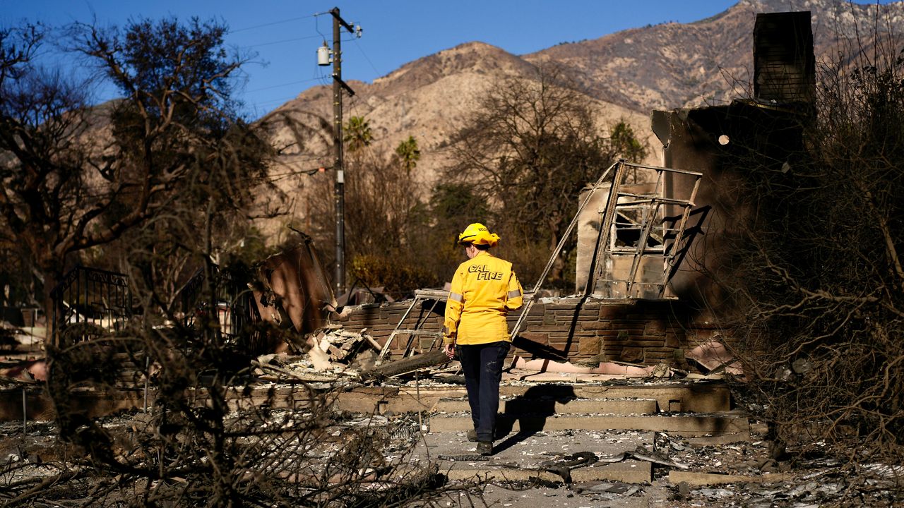 Cal Fire Forestry Technician Holly Helseth surveys the damage to a property in the aftermath of the Eaton Fire Monday, Jan. 13, 2025, in Altadena, Calif. (AP Photo/Carolyn Kaster)