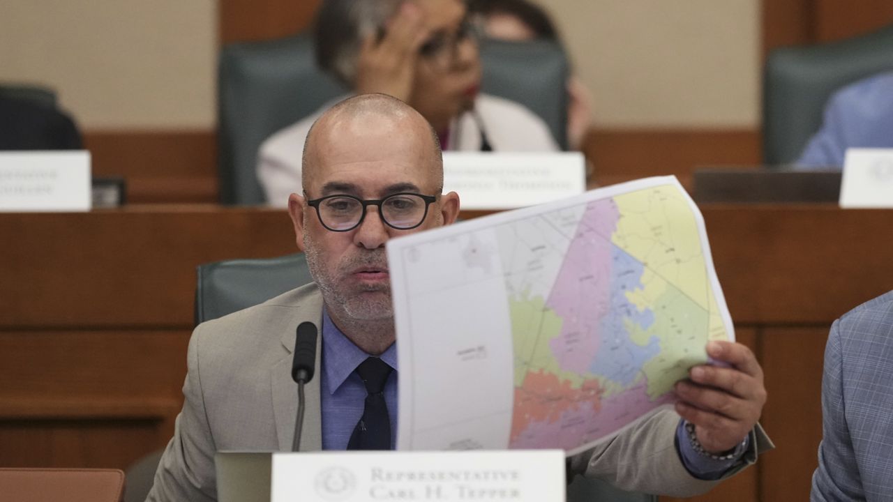 Texas state Rep. Carl H. Tepper, R-Lubbock, looks through U.S. Congressional District maps during a redistricting hearing at the Texas Capitol, Thursday, July 24, 2025, in Austin, Texas. (AP Photo/Eric Gay)