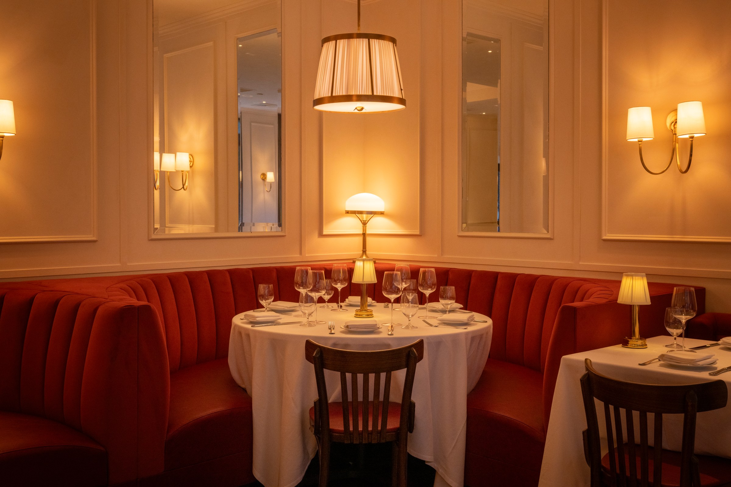 A restaurant dining table with red booths.