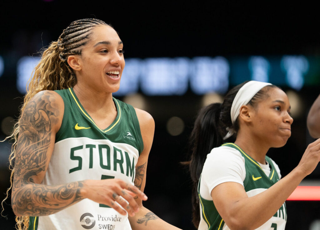 Seattle Storm forward Gabby Williams smiles next to a serious-looking guard Zia Cooke as they walk off the court in a game against the Las Vegas Aces on May 25, 2025 at Climate Pledge Arena in Seattle, Wash.