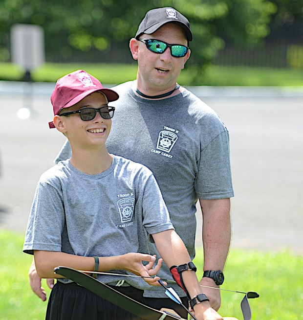 Buckingham Police Officer Steve Thomas with Gabe Dunn, 12, Springfield, on the archery range Monday at Troop K's Camp Cadet at Valley Forge Military Academy. (PETE BANNAN-DAILY TIMES)