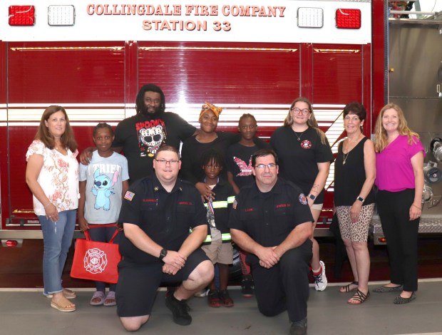At a recent ceremony honoring young hero Kah'ir Gibson, 6, center front, are, kneeling, Collingdale Fire Company 33 Deputy Chief Steve Johnson Jr., left, Collingdale Fire Prevention Officer Steve Zane; standing, from left, kindergarten teacher Aileen Crossman, Kah'ir's sister Isabella Gibson, his father Danron Gibson Sr., his mother Na'Shay Gibson, his sister Cattielya Gibson, station 33 Fire Prevention Officer MacKenzie Hays, Collingdale Mayor Donna Matteo-Spadea, Southeast Delco Kindergarten Academy school counselor April Kessler. (COURTESY OF JOY WINNER)