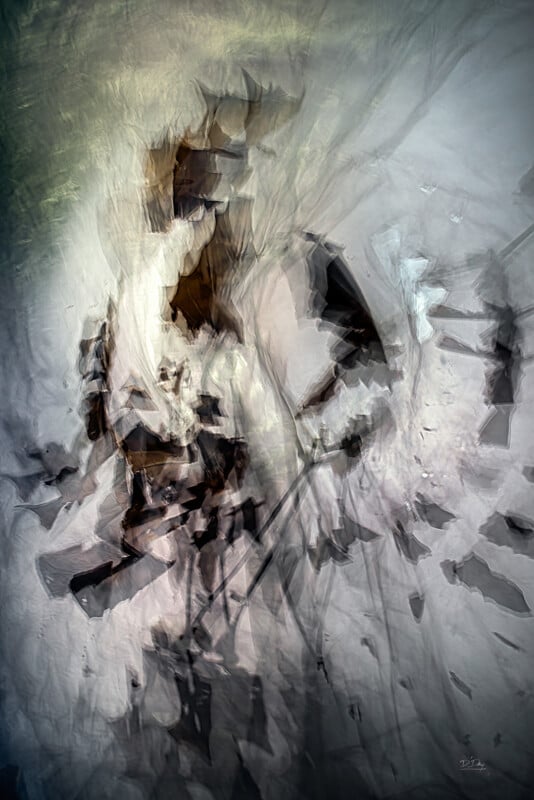 Abstract digital artwork featuring blurred, fragmented shapes in shades of brown, black, and gray on a textured, light background. The forms appear layered and dynamic, creating a sense of movement and depth.