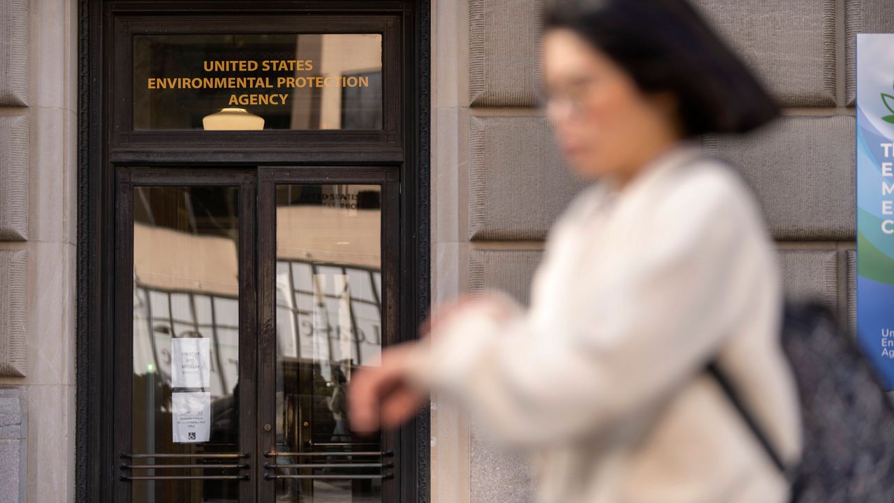 A person walks past the headquarters building of the Environmental Protection Agency, March 12, 2025, in Washington. (AP Photo/Mark Schiefelbein)