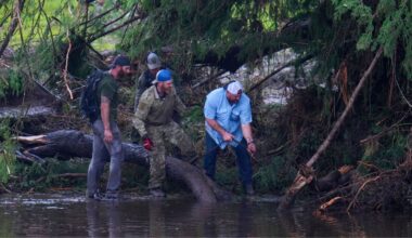 People remove debris from the Guadalupe River while inspecting an area at Camp Mystic, Sunday, July 6, 2025, in Hunt, Texas, after a flash flood swept through the area. (AP Photo/Julio Cortez)