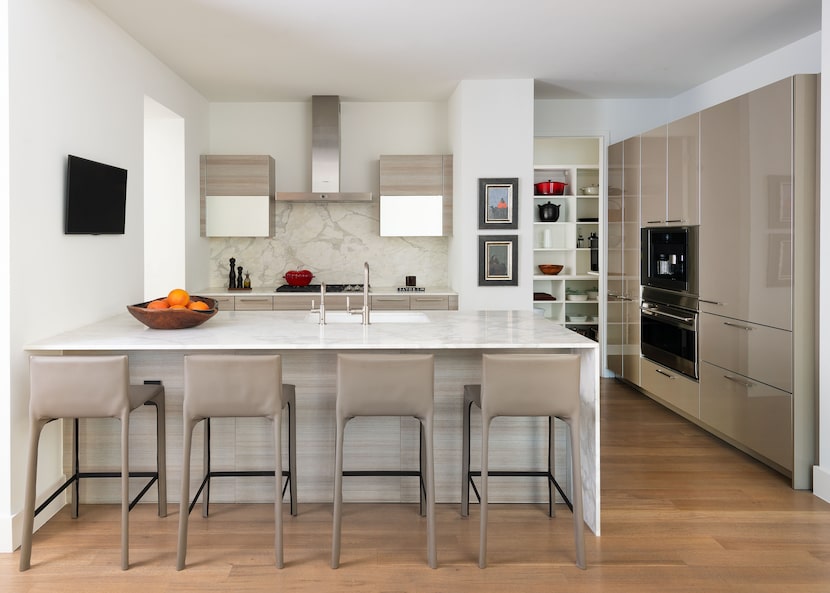 The updated kitchen features marble waterfall countertops, Poggenpohl cabinetry, and leather...