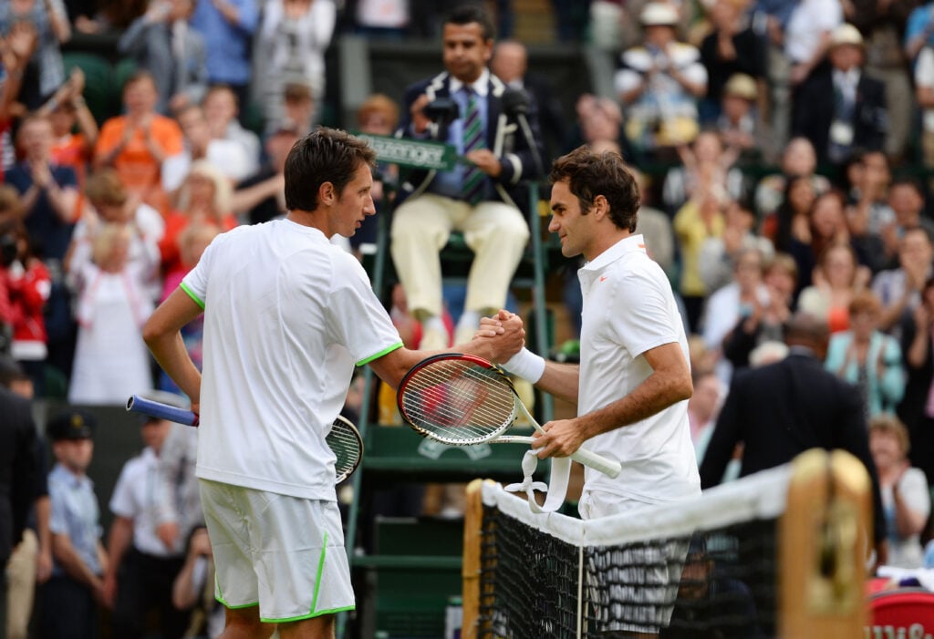 Sergiy Stakhovsky of Ukraine shakes hands at the net with Roger Federer of Switzerland after their Gentlemen's Singles second round match on day three of the Wimbledon Lawn Tennis Championships at the All England Lawn Tennis and Croquet Club.