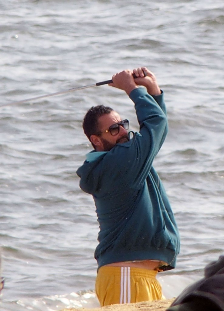 Man playing golf by the ocean.