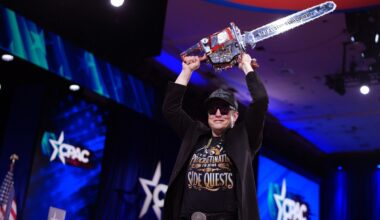 CEO of Tesla and SpaceX Elon Musk holding a chainsaw above his head.