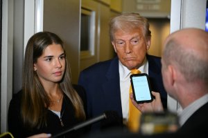 US President Donald Trump (C) listens to reporters as his granddaughter Kai Madison Trump looks on on board Air Force One while flying from Miami to Palm Beach on April 13, 2025, after watching the featherweight fight between Australian fighter Alexander Volkanovski and Brazilian fighter Diego Lopes (R) during UFC 314 at the Kaseya Center in Miami. (Photo by Mandel NGAN / AFP) (Photo by MANDEL NGAN/AFP via Getty Images)