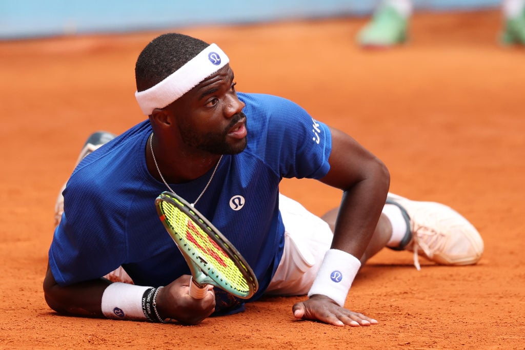 Frances Tiafoe of the United States lies on the clay after returning a shot during his Men's Round of 16 match against Matteo Arnaldi of Italy on Day Nine of the Mutua Madrid Open at La Caja Magica on April 30, 2025 in Madrid, Spain.