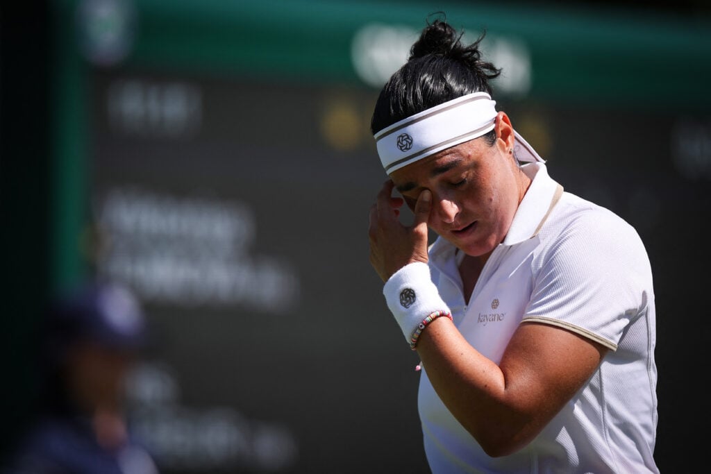 Ons Jabeur reacts as she plays against Bulgaria's Viktoriya Tomova during their women's singles first round tennis match on the first day of the 2025 Wimbledon Championships at The All England Lawn Tennis and Croquet Club in Wimbledon.