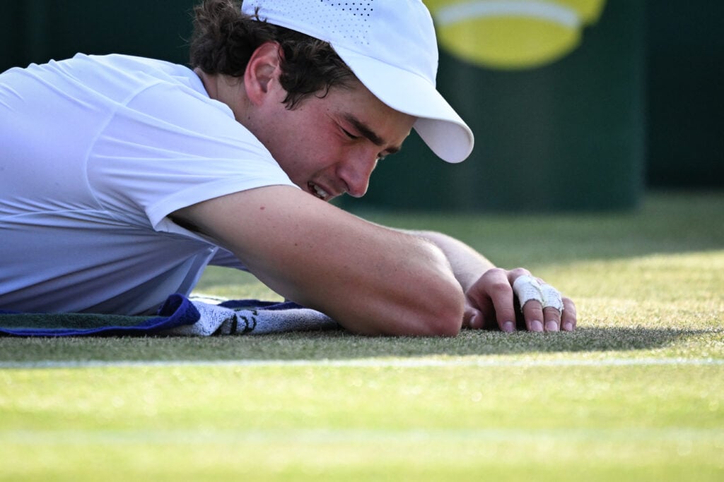 Joao Fonseca reacts while receiving medial treatment at Wimbledon.