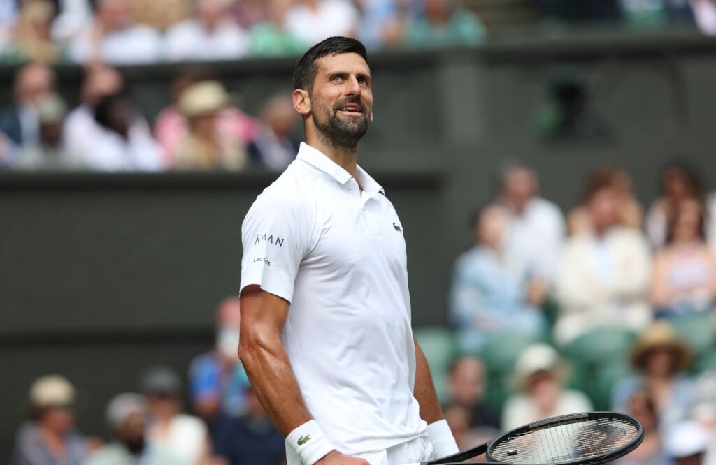 Novak Djokovic smiles, looking up