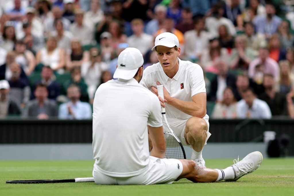 Jannik Sinner checks on an injured Grigor Dimitrov during their Wimbledon clash in 2025.