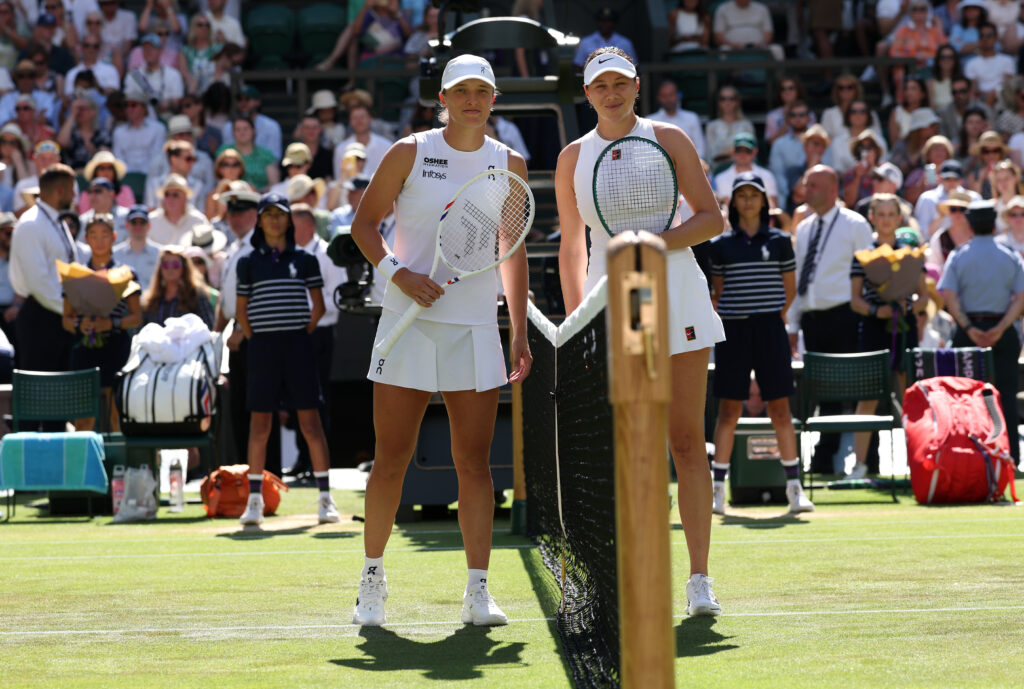 Amanda Anisimova and Iga Swiatek pose at the net