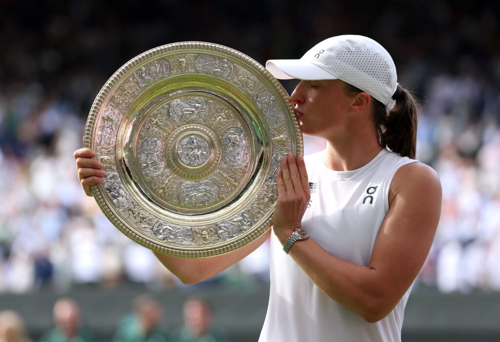 Iga Swiatek of Poland kisses the Ladies’ Singles Trophy following her victory against Amanda Anisimova of United States during the Ladies' Singles Fina on day thirteen of The Championships Wimbledon 2025 at All England Lawn Tennis and Croquet Club.