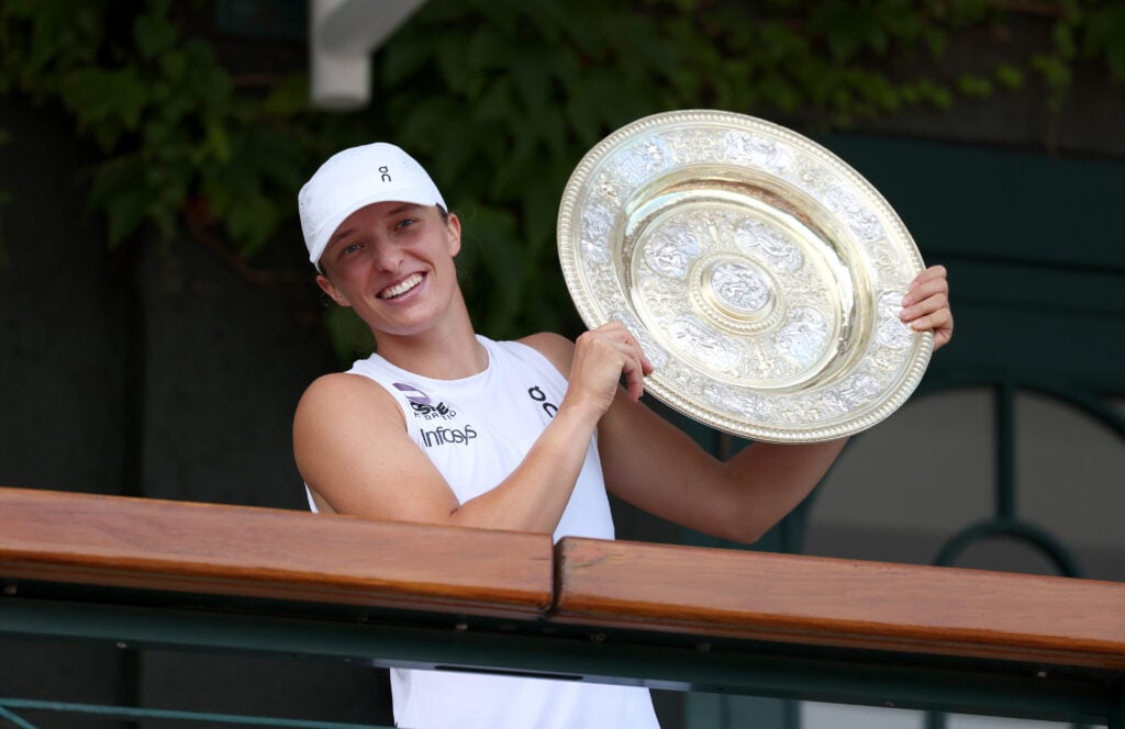 Iga Swiatek of Poland poses with the Ladies’ Singles Trophy on the Clubhouse Balcony, following victory against Amanda Anisimova of United States during the Ladies' Singles Final on day thirteen of The Championships Wimbledon 2025 at All England Lawn Tennis and Croquet Club.