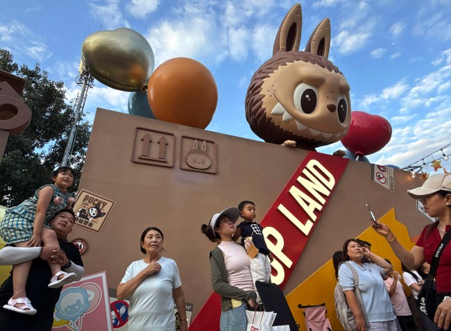 BEIJING, CHINA - JULY 16: Visitors watch a performance of Pop Mart's hugely popular Labubu dolls series at the Pop Land theme park on July 16, 2025 in Beijing, China. The viral 'monster' dolls are so popular that Pop Mart, the Beijing-based company behind the craze, saw its profits soar by 350% in the first half of the year.  The obsession with Labubu, furry creatures with pointy ears and exactly nine teeth, have inspired long lineups and occasional tussles in some countries as well as a growing black market for imposter products seeking to cash in. Labubu dolls, created by Hong Kong artist Kasing Lung, first debuted in 2019 but hit global status more recently when they became the accessory toy of choice for celebrities including Rihanna, Dua Lipa, and Blackpink's Lisa. A key part of Pop Mart's commercial success with Labubu is so-called 'blind boxes' where customers find out what they buy only when they open the package.(Photo by Kevin Frayer/Getty Images)