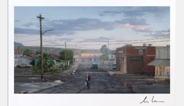 A person stands alone on a cracked, empty street in a small, deserted town at dusk, surrounded by rundown buildings and palm trees under a cloudy sky.