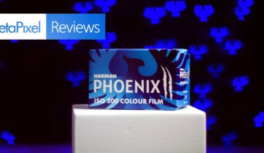 A box of Harman Phoenix ISO 200 Colour Film sits on a white platform against a dark background with blue abstract shapes, with a "PetaPixel Reviews" banner in the top left corner.