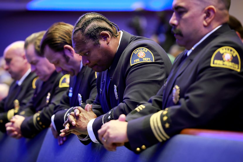 Dallas Fire-Rescue firefighters, including driver/engineer Kevin Middleton (center), bow...