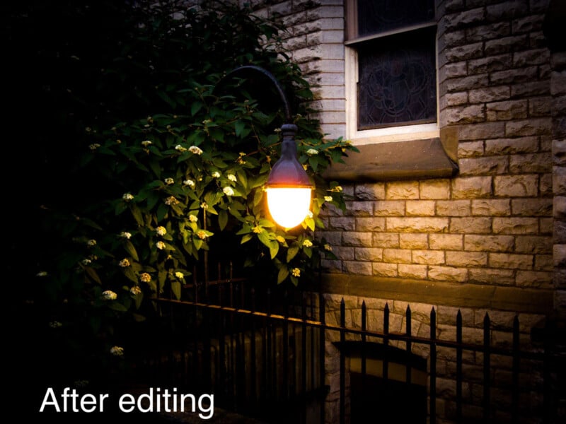 A glowing street lamp illuminates green foliage and a brick wall near a window at dusk. Iron railings run along the foreground. The words "After editing" appear in white text at the bottom left.