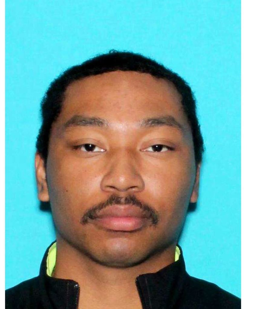 Mugshot of a man with short dark hair and a mustache.