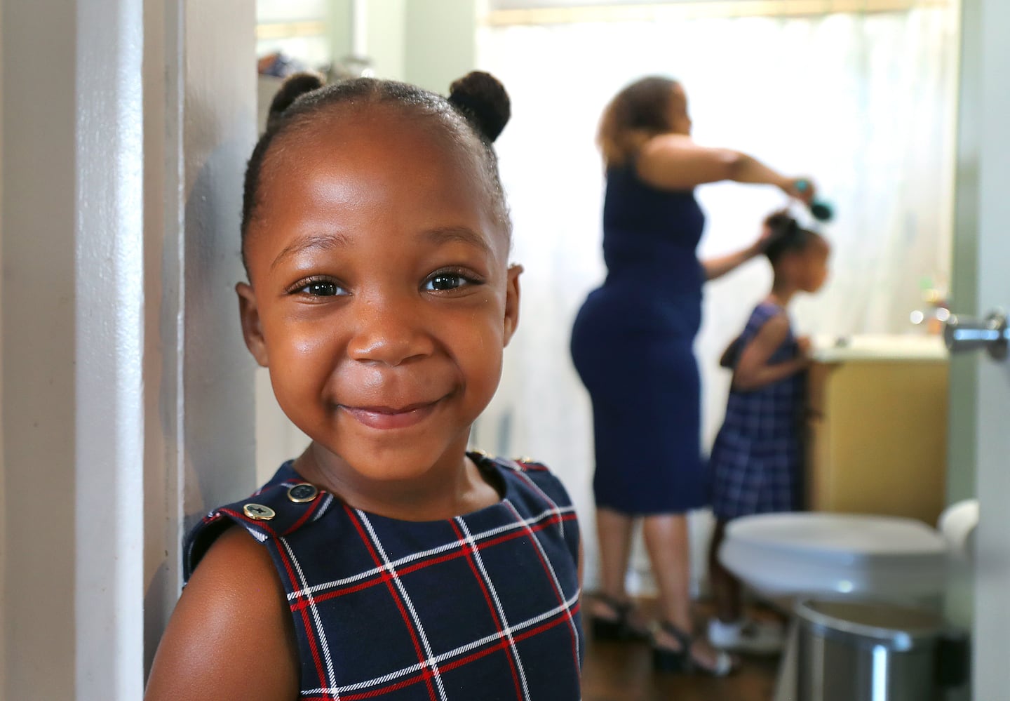 Diana Cortes worked on the hair of daughter, Arya, 5, as her sister, Layla, stood in the doorway to the bathroom in their Methuen apartment. Medicaid covered Layla's life-saving liver transplant in June 2023.