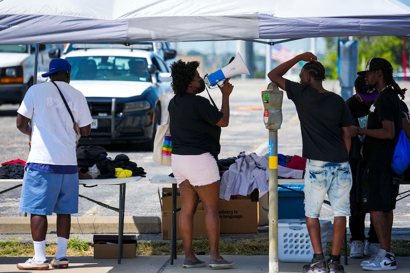Dallas City Marshal watches from a parking lot as volunteers with the aid group Dallas...