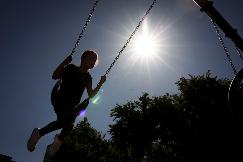 Anabelle Herrera, 9, swings in the backlight of the July sun, on Thursday, July 24, 2025, at...