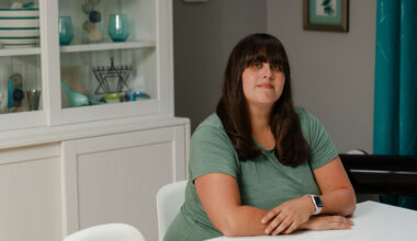 A portrait of a woman sitting at a dining room table.