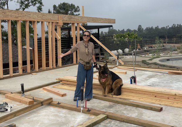 Contractor Jun Li Lujan, 63, of Pasadena shows off the framing for the home that's replacing the house she lost in the Eaton fire last January. In addition to rebuilding her house, Lujan is converting her garage into a 493-square-foot ADU. "I don't need a parking space. I need a small living space," Lujan said. "I have a lot of friends. A guest can come over (and) use that." (Photo courtesy of Jun Li Lujan)
