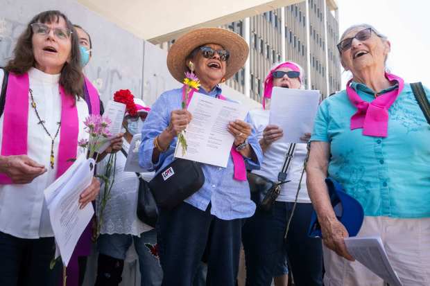 An interfaith gathering begins their weekly vigil at the Federal...