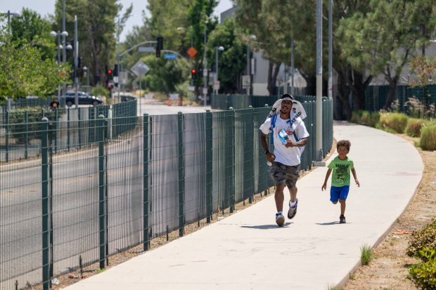 A man and child run to catch a bus at...