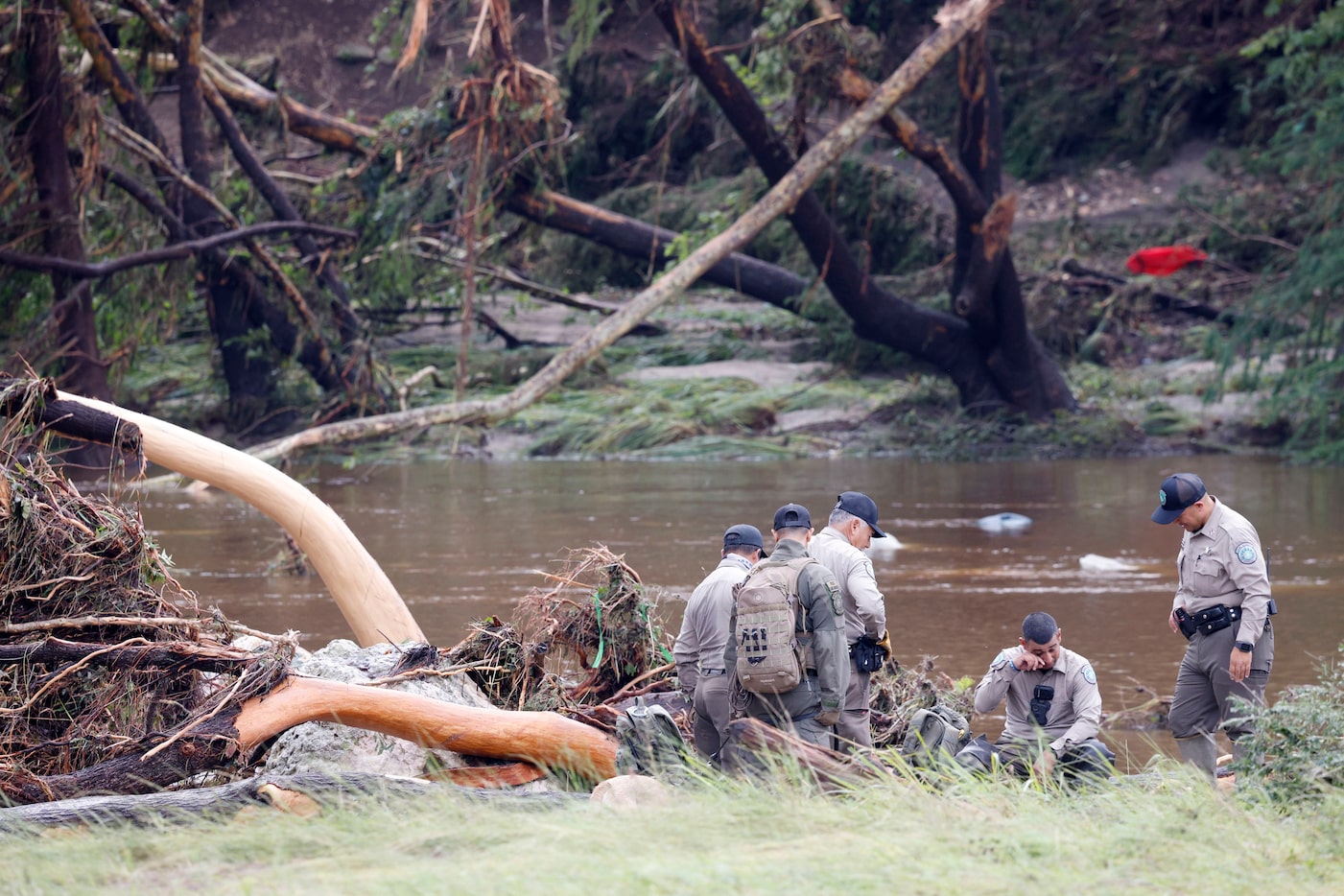 Law enforcement officers gather along the Guadalupe River, Saturday, July 5, 2025, in Hunt....