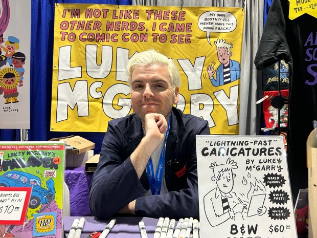 Cartoonist Luke McGarry poses for a photo at his booth...