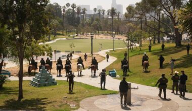 Federal agents ride on horseback at MacArthur Park Monday, July 7, 2025, in Los Angeles.