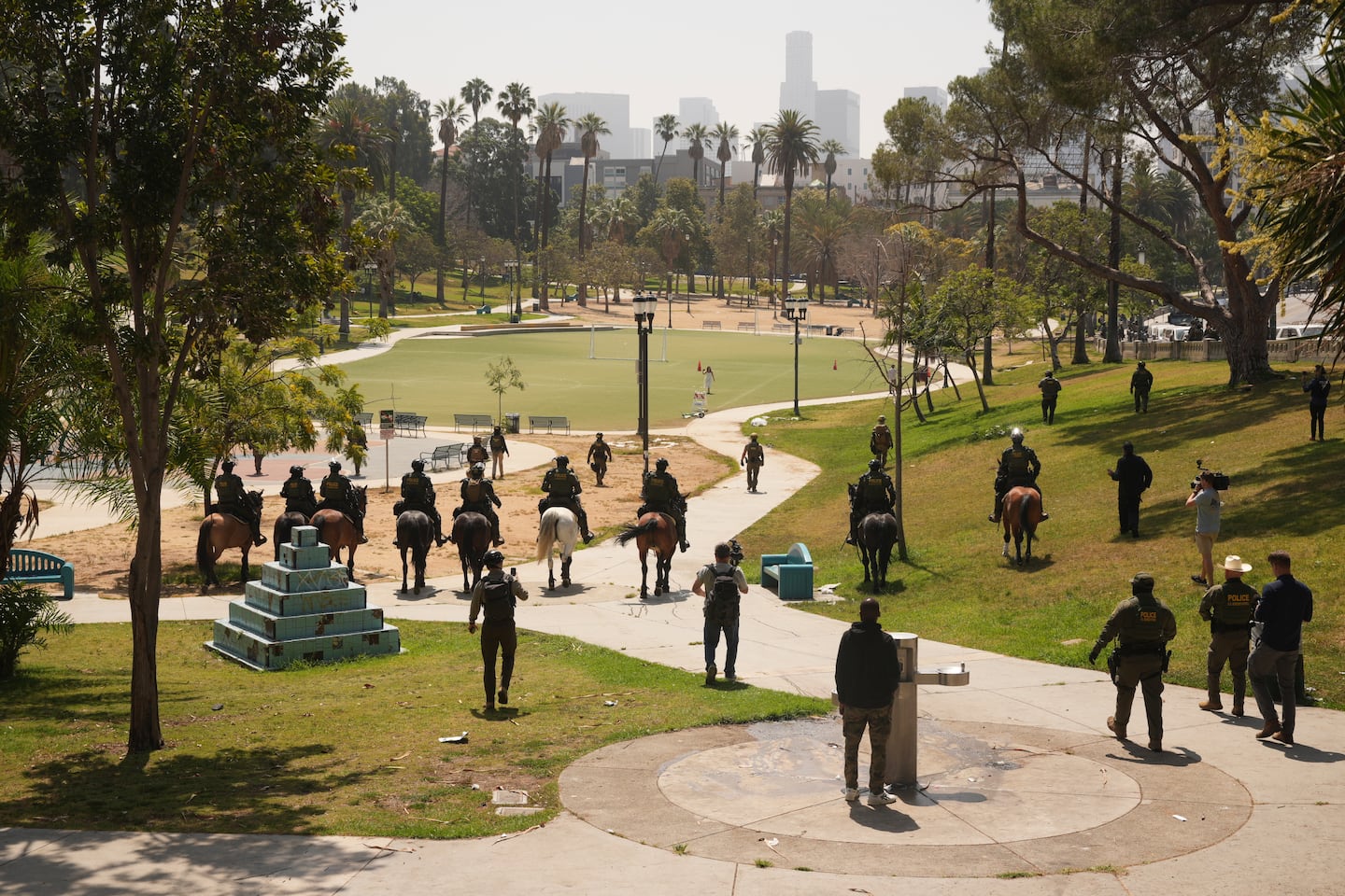 Federal agents ride on horseback at MacArthur Park Monday, July 7, 2025, in Los Angeles.