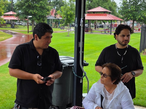 Julio Ibarra, left, translates Notre Dame Professor Emiliano Aguilar's talk for Alicia Mayo, center, while her son Salvador Mayo listens during the Just Transitions Northwest Indiana Industrial Heritage Bus tour Saturday, July 19, 2025. (Michelle L. Quinn/for Post-Tribune)